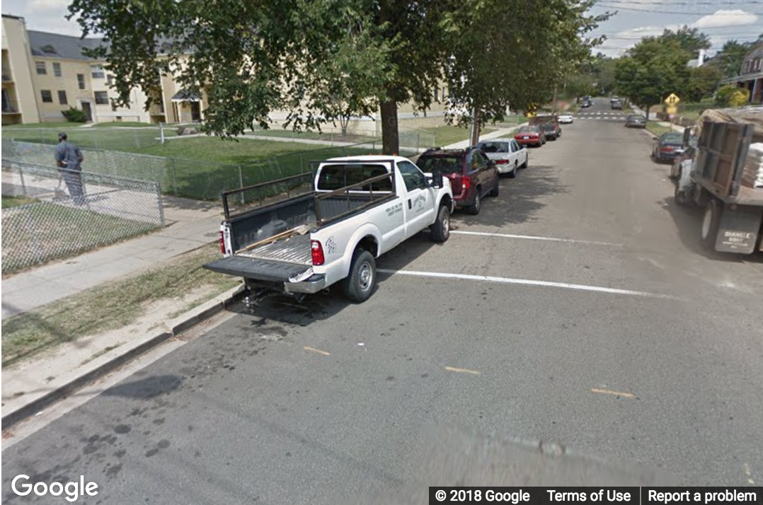 A Street View image of a truck blocking the view of a possible curb ramp